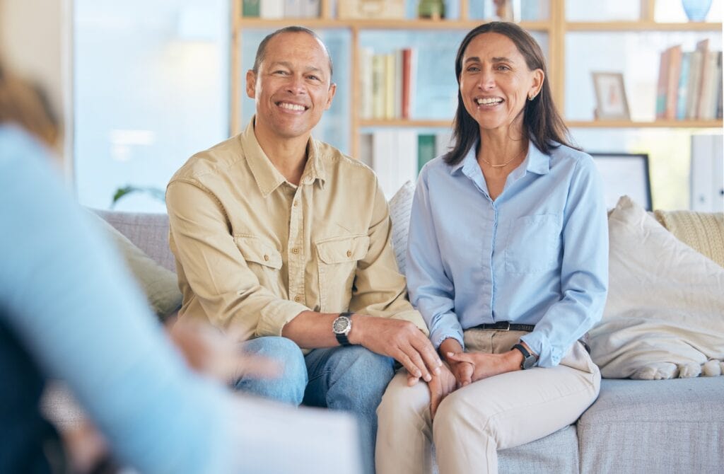 marriage therapy concept, couple smiling while having a conversation with therapist