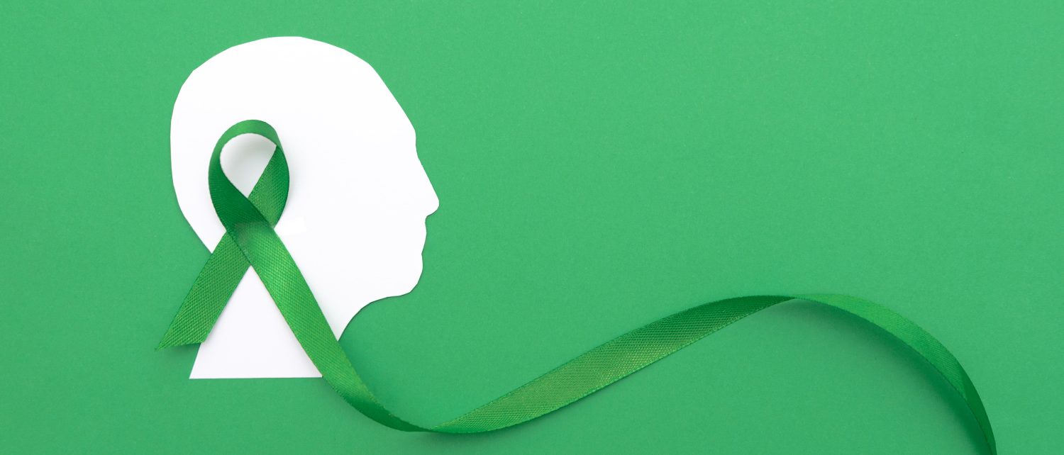 Mental Health Awareness - Silhouette of a Human Head with large Green Ribbon on Green Background (1)