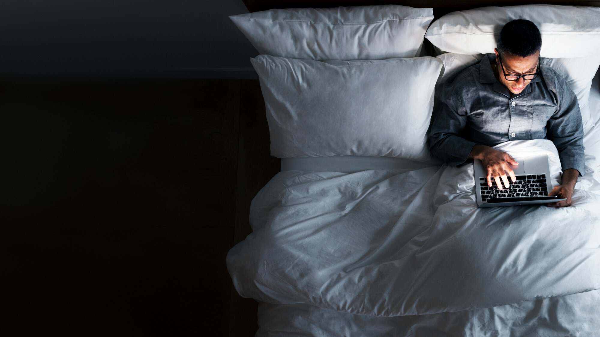 man using laptop while on bed